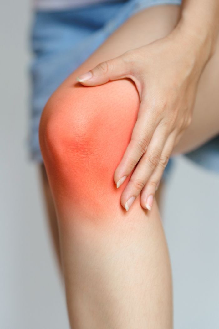 Person Holding Knee in Pain